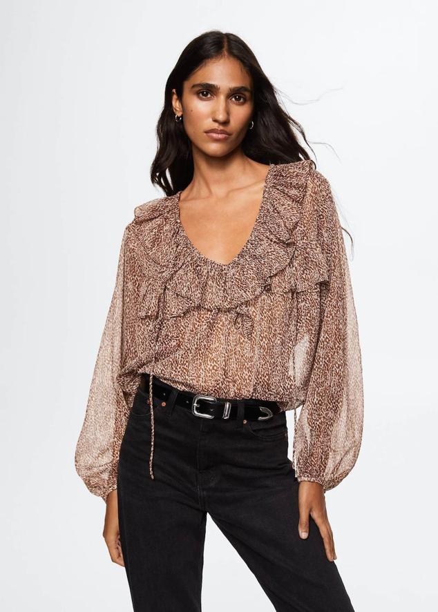 Blusa en tejido ligero vaporoso con cuello de pico, manga larga ligeramente abombada, cuerpo fluido y detalle de volantes, en animal print, de Mango. Su coste es de 29,99 euros.