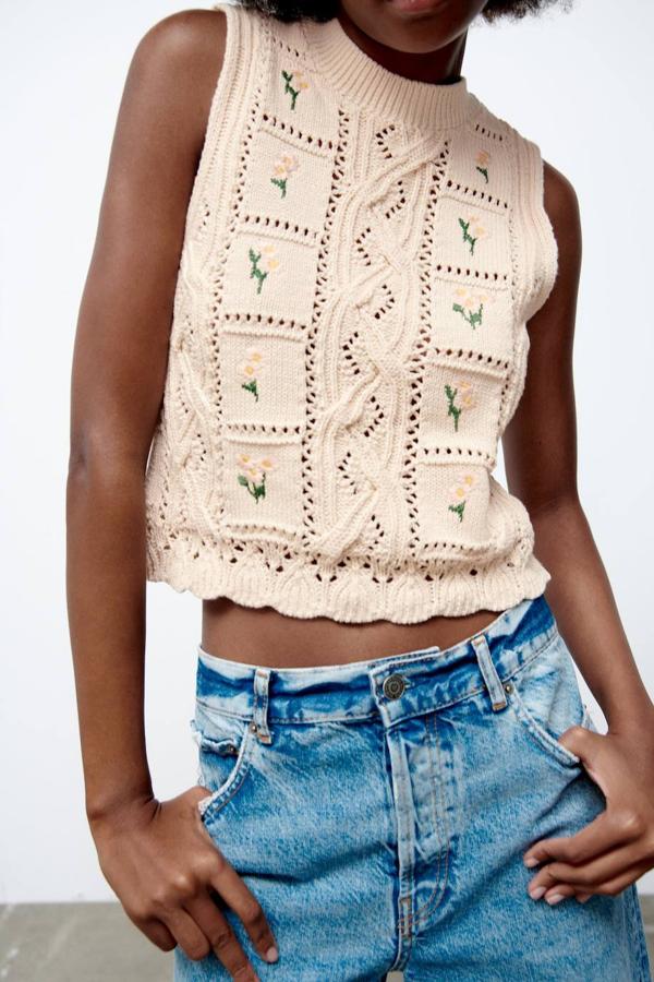 Chaleco de punto con manga sisa, cuello redondo, detalle trenzados y calados, bordado de flores y bajo festoneado, color arena, de Zara. Su coste es de 22,95 euros.