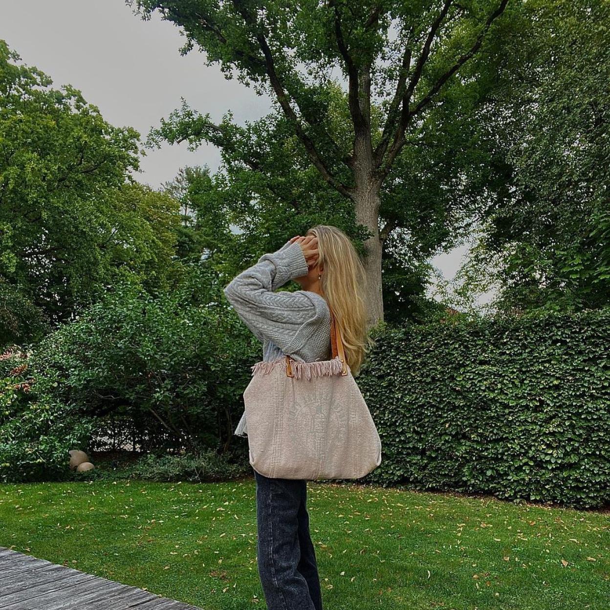 La influencer Lotta Emilie Stichler con un pantalón vaquero de corte recto y un jersey de punto gris. 