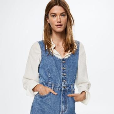 Imagen secundaria 1 - El vestido vaquero más buscado del momento está en Mango. Es tipo peto, lleva botones y lo podrás estrenar ahora con tu blusa blanca preferida. Peto vaquero de Mango (39,99 euros). 