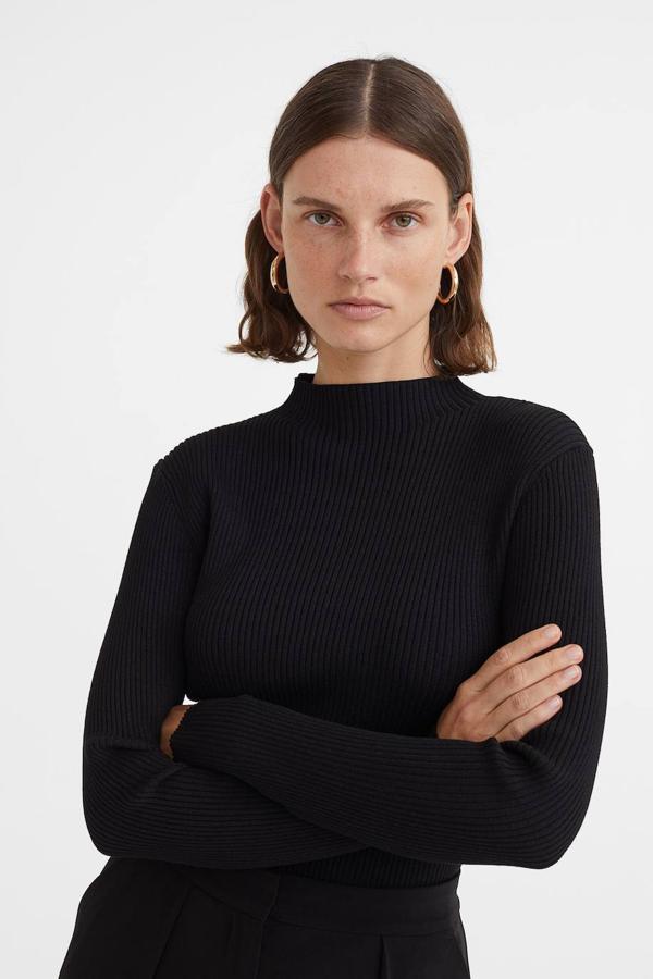 Jersey en punto suave de canalé con corte acomodado al cuerpo, manga larga y cuello elevado, color negro. Puedes comprarlo por 19,99 euros.