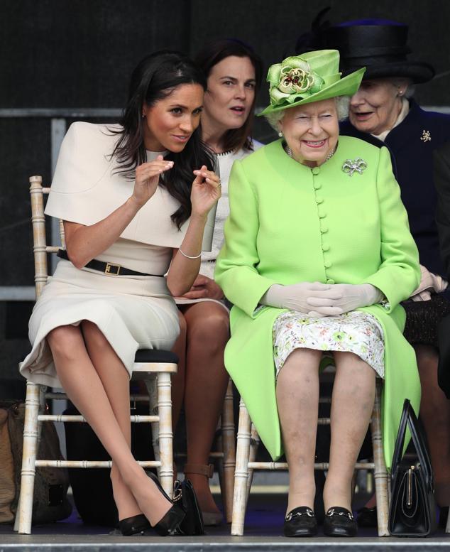 En el primer acto en solitario de la actriz norteamericana tras su boda con Harry estuvo acompañada de Isabel II, con la que compartió confidencias.