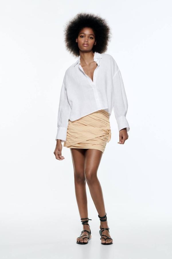 Camisa cropped con diseño oversize confeccionada en tejido 100% de lino con silueta relajada y manga larga con puño ancho, color blanco, de Zara. Su coste es de 27,95 euros.