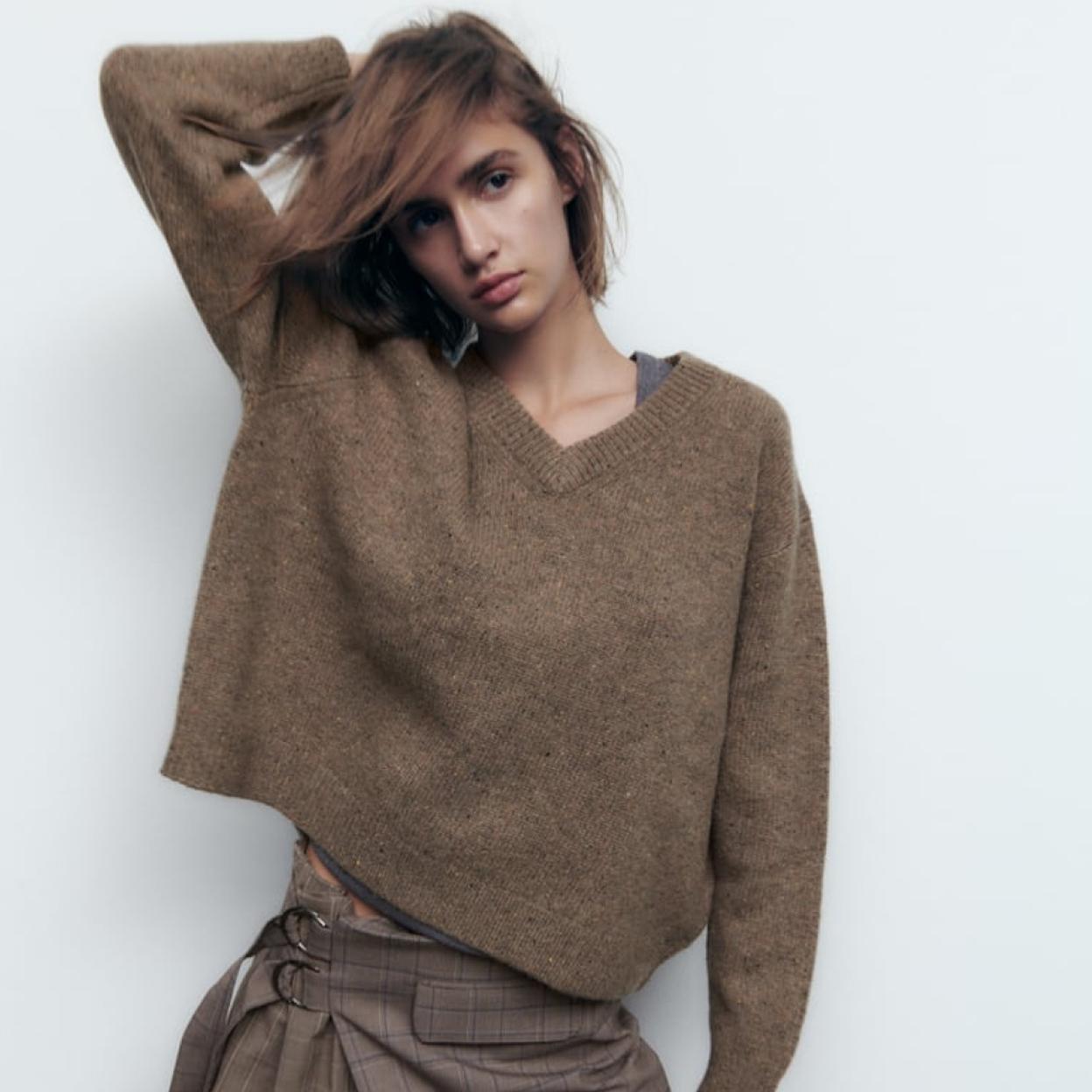 La modelo de Zara combina la falda viral con un jersey marrón y unas botas por las rodillas también marrones.