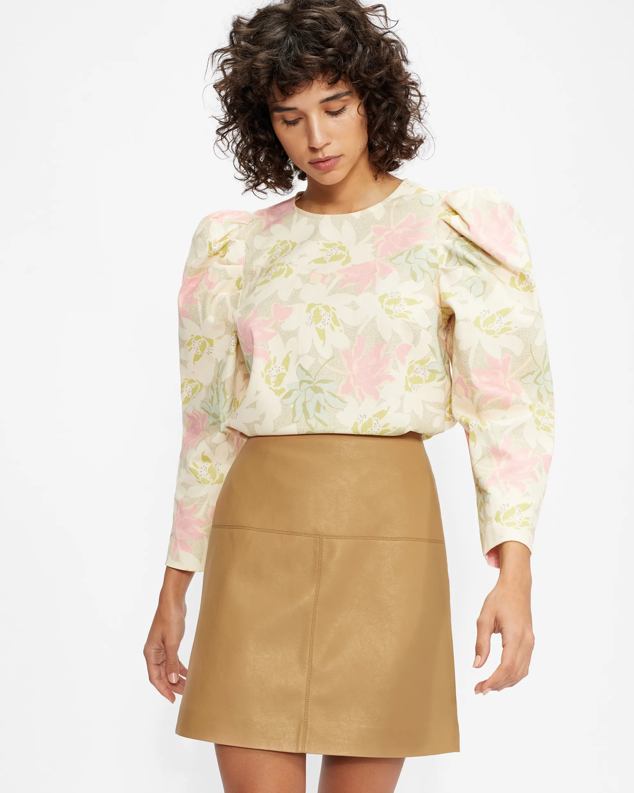 Falda corta efecto piel en color camel para combinar con blusas románticas o boho-chic. Una prenda perfecta para ir a la oficina con tacones. Es de Veeria. Precio: 175 €.