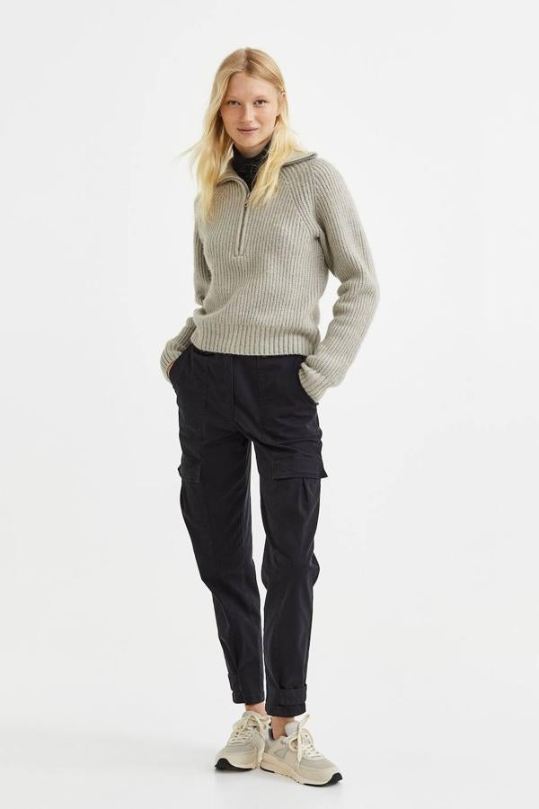 Pantalón largo de estilo cargo con talle alto, bolsillos de plastrón en lar perneras y trabillas ajustables en el bajo, color negro, de H&M. Cuesta 34,99 euros.