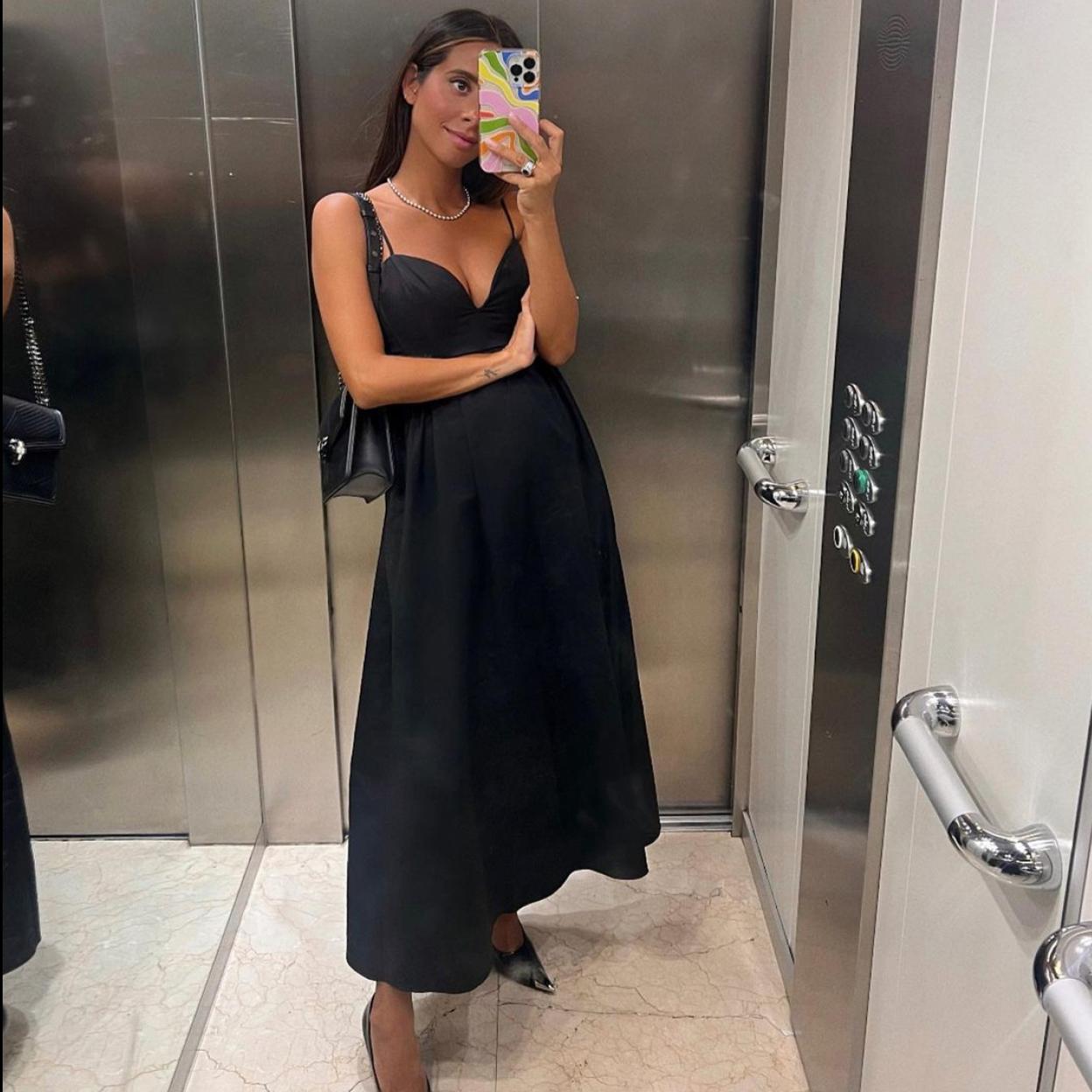 La influencer luce un vestido negro de tirantes con escote de corazón y unas sabrinas acabadas en punta.