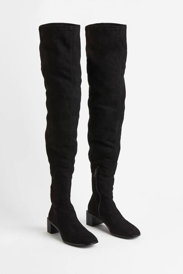 Botas altas mosqueteras confeccionadas en tejido efecto serraje con caña ajustada y tacón bajo, en negro, de H&M. Su coste es de 59,99 euros.