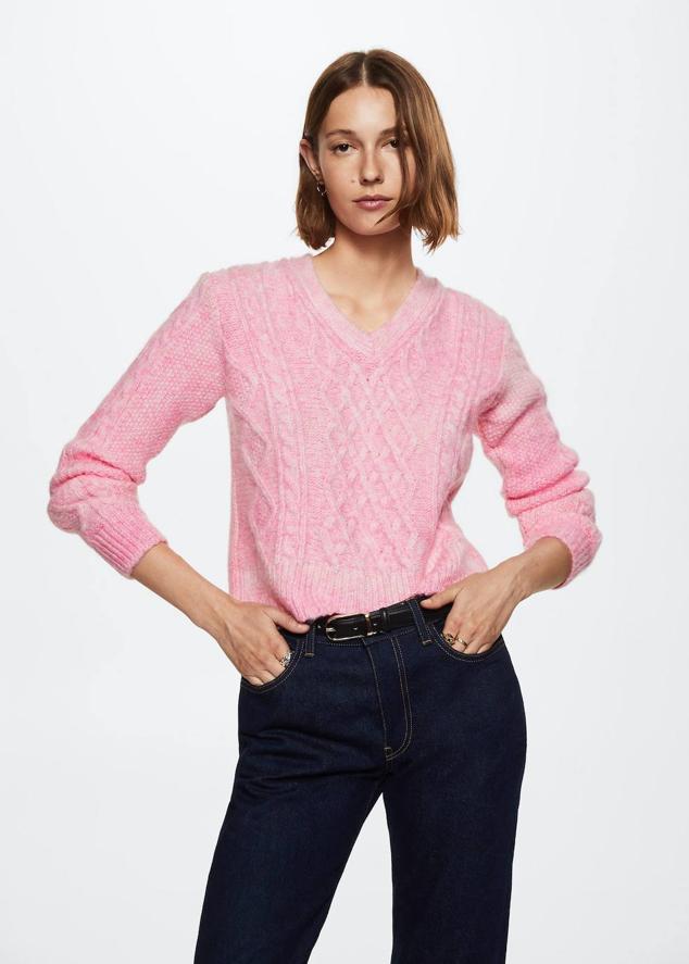Jersey de punto trenzado con escote de pico, detalles en relieve y manga larga, en tono rosa claro desgastado, de Mango. Puedes comprarlo por 35,99 euros.