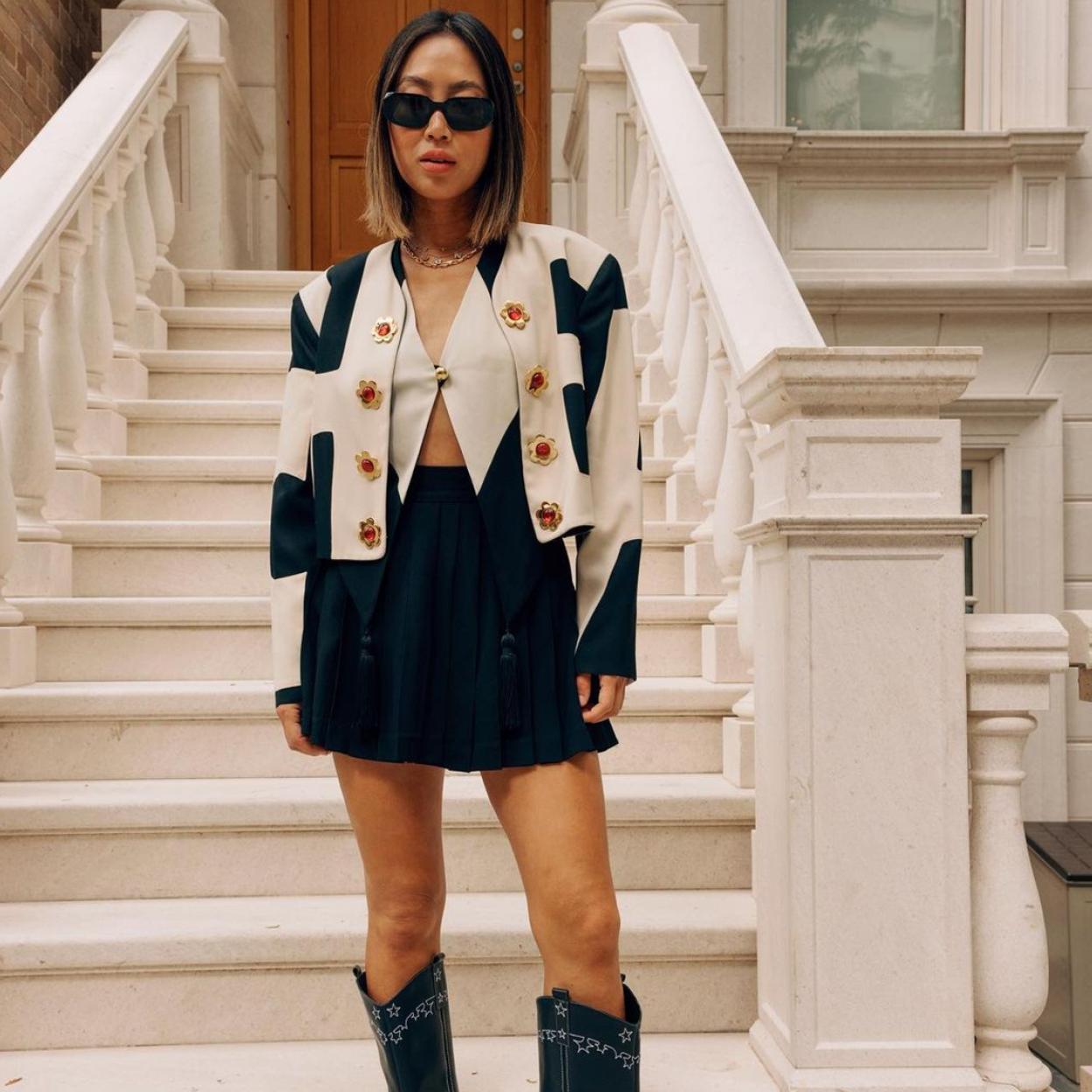 La influencer luce unas botas cowboy con unas bermudas de color negro y una camisa con una chaqueta corta. 