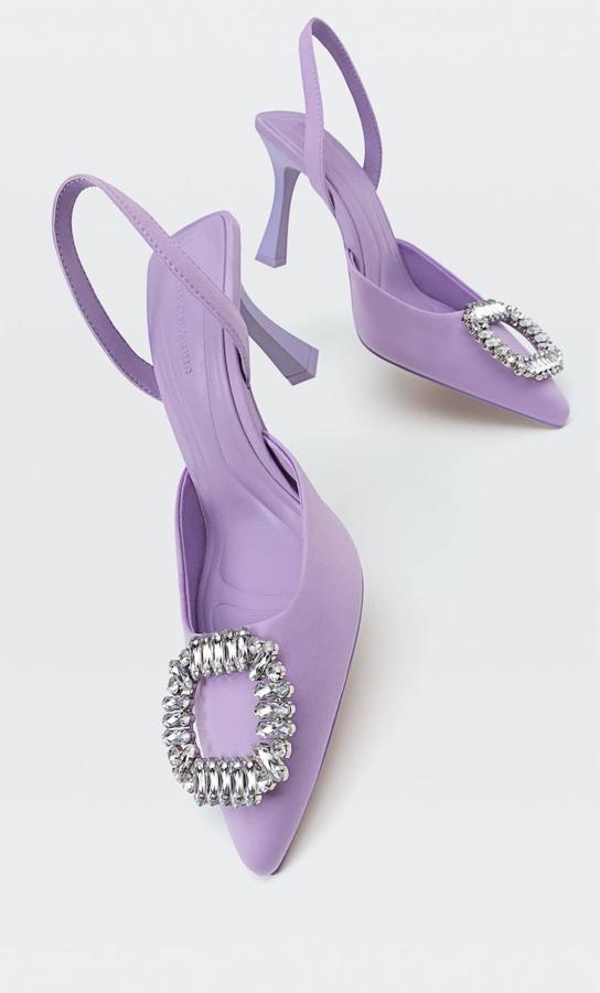 Zapatos de tacón terminados en punta con diseño destalonado, tira trasera para el talón y adorno de hebilla enjoyada, color morado claro, de Stradivarius. Tiene un precio de 39,99 euros.