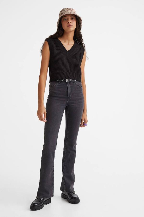 Vaqueros de corte ajustado en tejido elástico con pernera bootcut, tiro alto, bolsillos y trabillas para el cinturón, en negro, de H&M. Los comprarás a 24,99 euros.