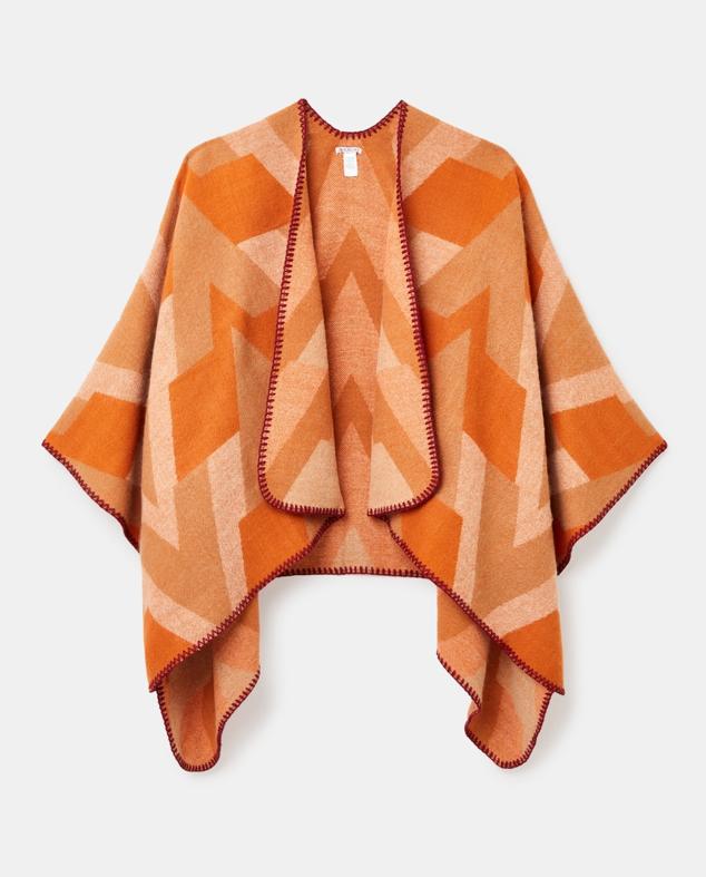 Poncho en color naranja intenso con estampado geométrico y acabo pespuntado. Es de Jo & Mr. Joe, pero puedes hacerte con este diseño en El Corte Inglés. Precio: 39,95 €. Cómpralo aquí