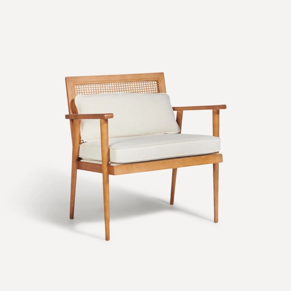 Los sillones de madera están de plena tendencia pues aportan un punto de diseño nórdico ideal. Este de ratán con cojines tapizados cuesta 499 euros. Cómpralo aquí