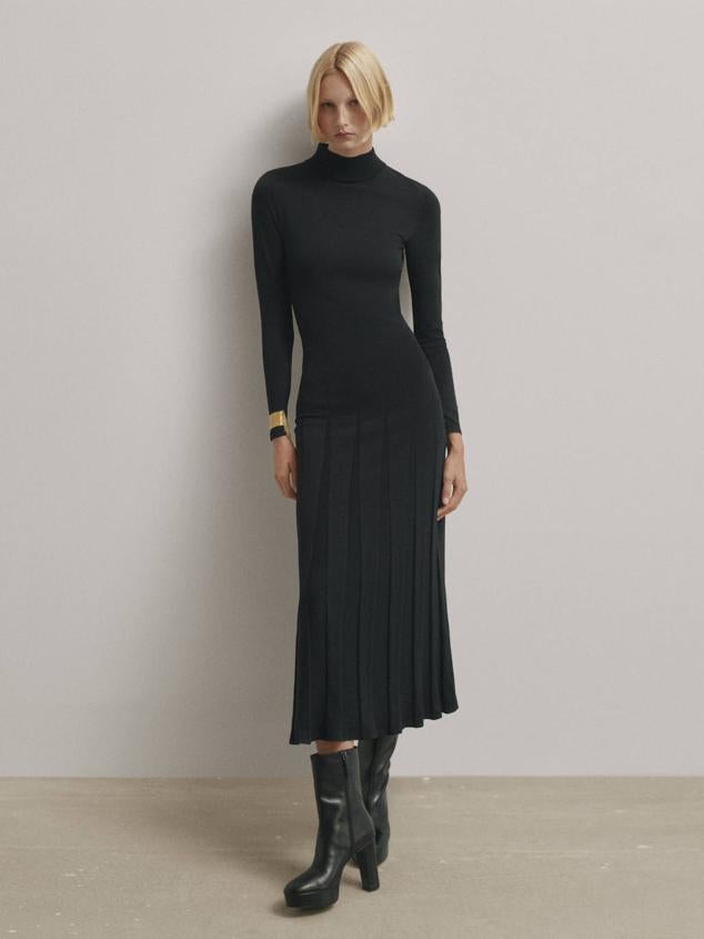Vestido midi entallado en tejido de punto con falda de tablas con vuelo, manga larga, espalda abierta con lazadas y cuello alto, en negro, de Massimo Dutti. Cómpralo por 129 euros.