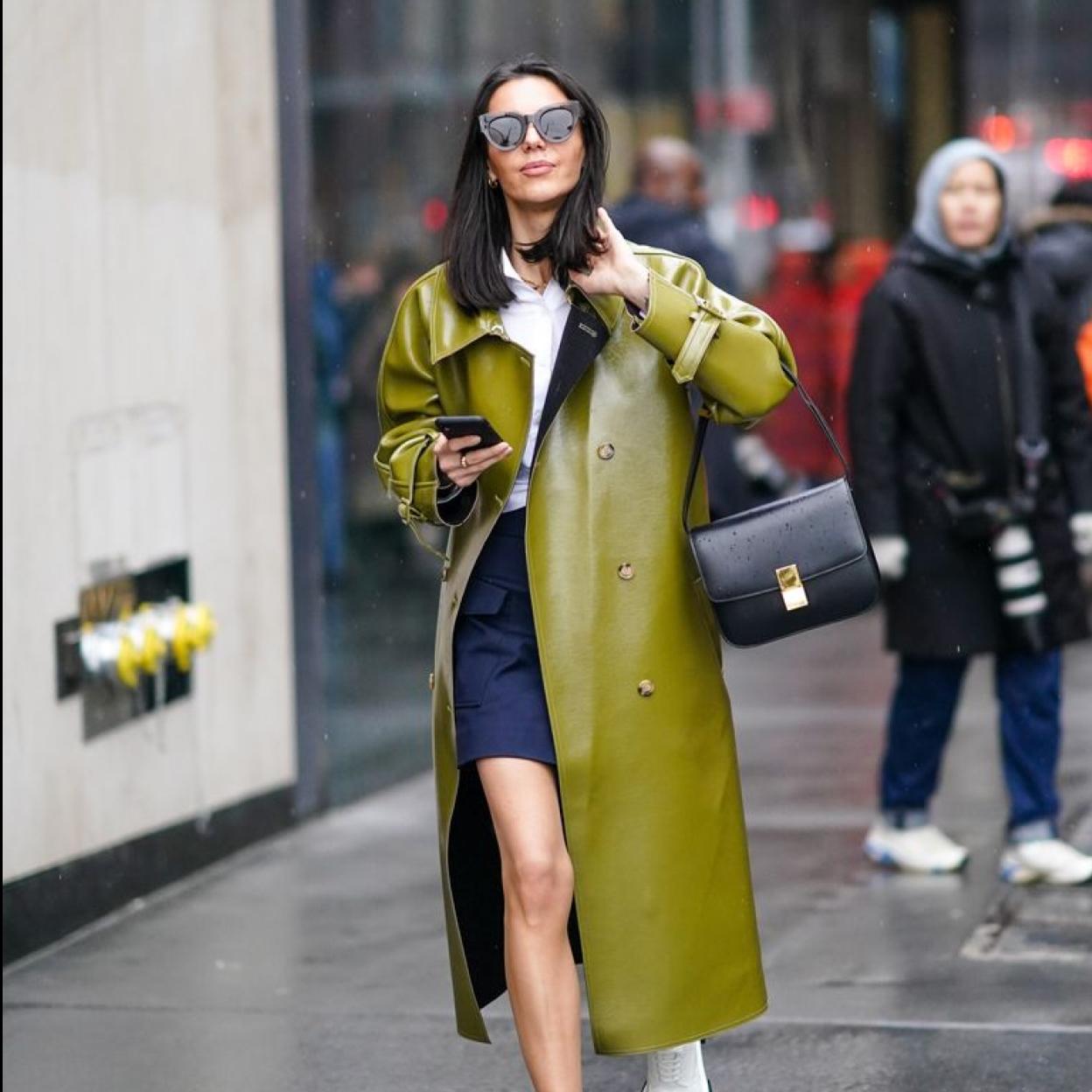 La influencer lleva una gabardina verde de piel.