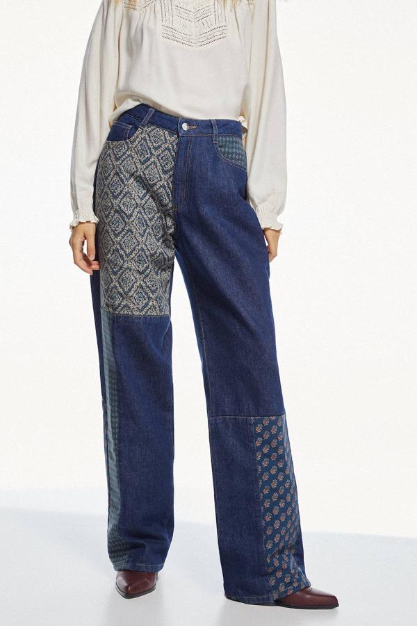 Jeans Patchwork con pernera wide leg extra larga, tiro alto, cinco bolsillos y detalles estampados a contraste, de Slow Love. Están disponibles en Springfield por 69,99 euros.