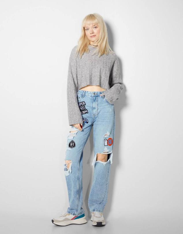 Jeans straight con tiro alto, bolsillos, detalles rotos y parches bordados, de Bershka. Puedes comprarlos a 35,99 euros.