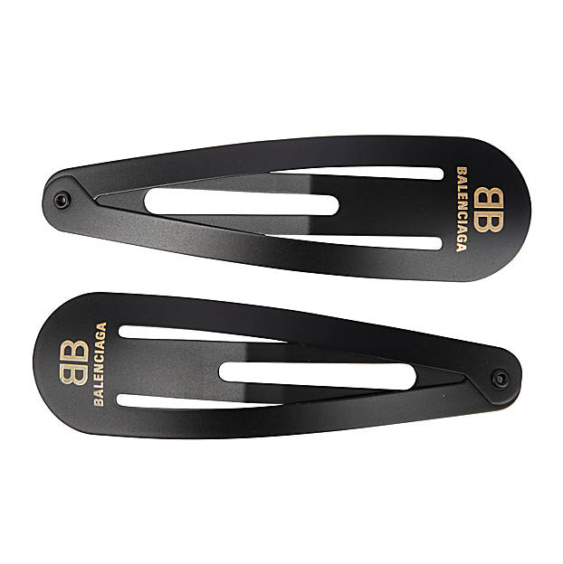 Imagen principal - Horquillas de clip de Balenciaga (225€); Diadema con detalles de brillo de Gucci (370€) y Pasadores con logo de Prada (360€).