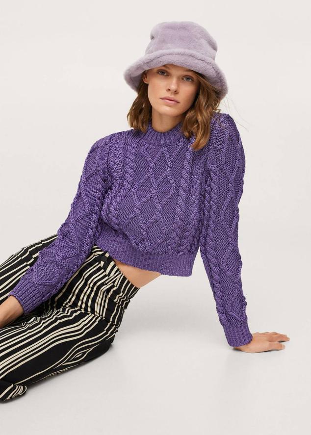 Jersey de punto en ochos con diseño cropped, manga larga, cuello redondo y acabado metalizado, en morado. Encuéntralo a 22,99 euros.