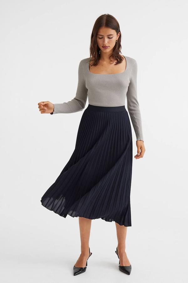 Falda midi plisada en tejido ligero con bajo acabado en evasé, tiro alto y cintura elástica, de H&M. Está disponible en azul, negro, marrón rojizo y verde oscuro, por 34,99 euros.