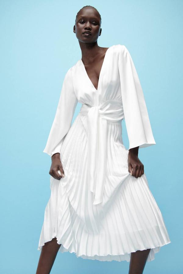 Falda midi plisada con tiro alto, forro y bajo acabado en evasé, color blanco, de Zara. Hazte con ella por 29,95 euros.