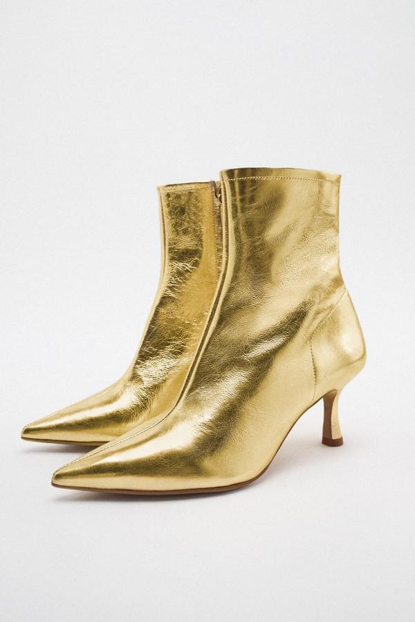Unso botines de tacón fino que pondrán la guinda a los los looks más básicos. Botines dorados de Zara (69,99 euros). 