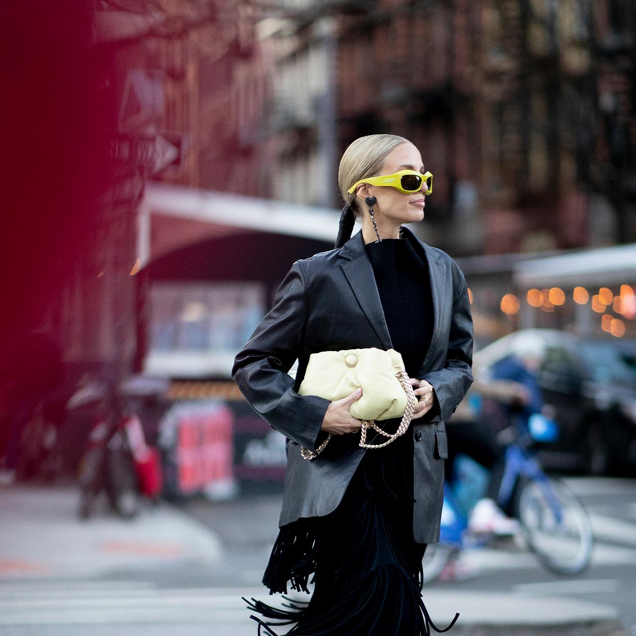 La influencer lleva una falda que combina con un básico de cuello alto negro y una americana de cuero también negra.