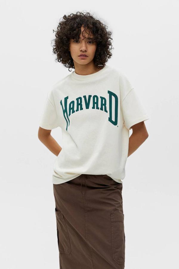 Camiseta de manga corta oversize estilo college con nombre de universidad, color arena, de Pull&Bear. Tiene un coste de 17,99 euros.