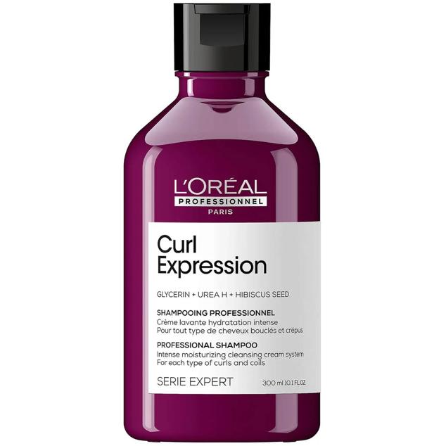 Curl Expression Moisturising and Hydrating Shampoo de L'Oréal Professionnel hdirata en profundidad y limpia el cabello con una fórmula cremosa que penetra en las fibras para desenredar, suavizar, acondicionar, fortalecer y sellar las cutículas, evitando que se produzca encrespamiento y procurando la remodelación del buclé. Para ello, se sive de la glicerina, urea, extracto de hibisco y ácido salicílico. Cómpralo aquí