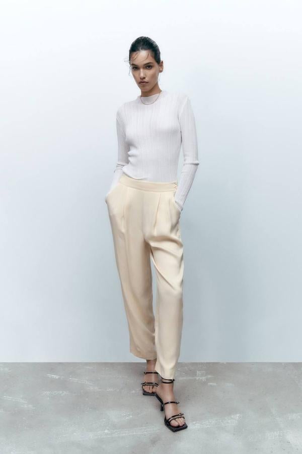 Pantalón jogger de vestir con pernera abombada, tiro alto, detalles de pinzas, bolsillos y cintura elástica, en tejido satinado color cava, de Zara. Cómpralos a 29,95 euros.