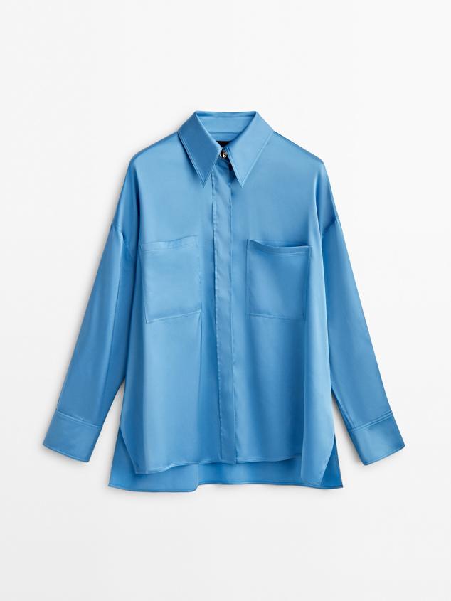 Camisa satinada fluida de color azul vibrante y con botonadura dorada que consigue un efecto de lujo. Es de Massimo Dutti. Precio: 99,95 €.