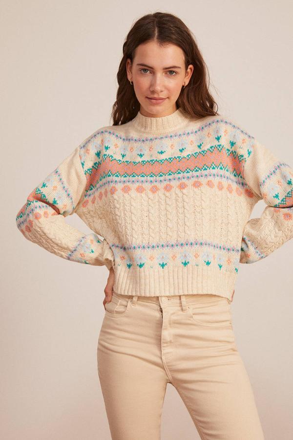 Jersey en tejido de punto trenzado con cuello redondo, manga larga, detalles acanalador y cenefas multicolor, en beige, de Springfield. Cuesta 31,99 euros.