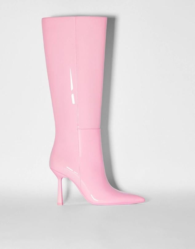 Botas altas con caña ancha, tacón fino, puntera puntiaguda y acabado brillante, en rosa, de Bershka. Está disponibles por 65,99 euros.