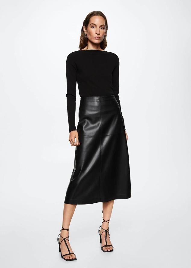 Falda midi en tejido efecto piel con tiro alto y bajo acabado en evasé, color negro, de Mango. Puedes encontrarla a 49,99 euros.