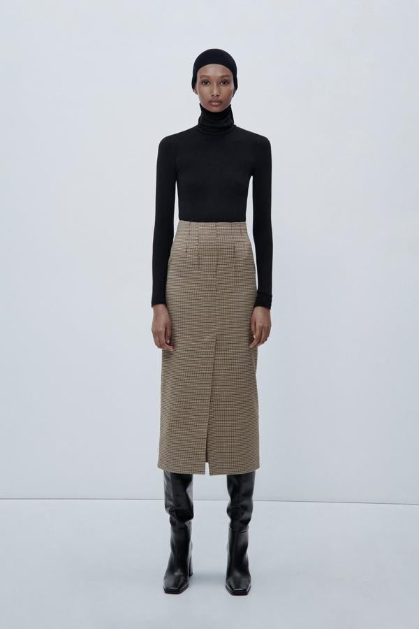 Un diseño muy favorecedor, que podrás llevar con tus botas altas favoritas. Falda midi con estampado de cuadros de Zara (39,99 euros). 