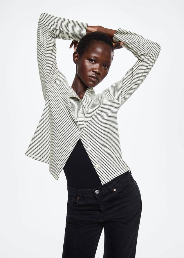 Cárdigan en tejido de punto fino con cuello redondo, manga larga, cierre de botones y estampado a rayas en blanco y negro, de Mango. Está disponible por 19,99 euros.