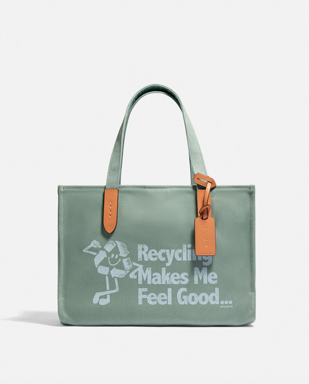 Bolso de mano de color verde con eslogan sobre el reciclaje, ya que está fabricado con materiales de este tipo. También, cuenta con cierre a presión para ir más cómoda. Tiene un descuento del 30%. Es de Coach. Precio rebajado: 94,50 €. Cómpralo aquí