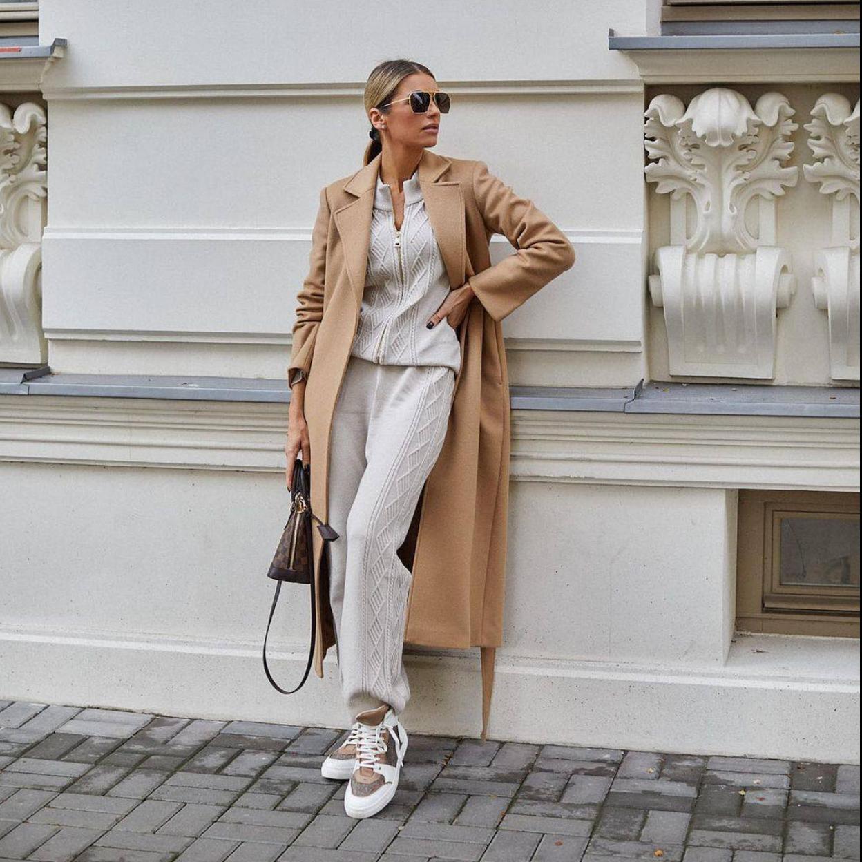 La influencer lleva un total look de punto en tonos neutros con abrigo camel, deportivas y bolso elegante