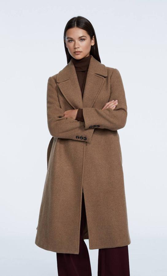 Abrigo midi con cuello solapa, manga larga, corte recto, hombros marcados, bolsillos y cierre de botón y cinturón de lazada, de Stradivarius. Encuéntralo a 59,99 euros.