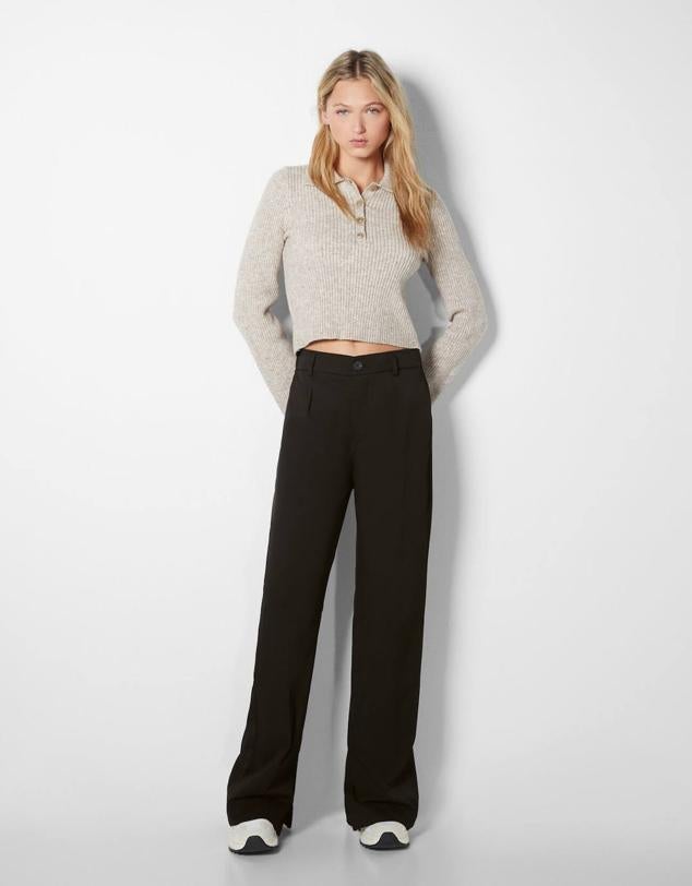 Pantalones de traje con perneras rectas y holgadas, tiro alto, pinzas y bolsillos, color negro, de Bershka. Están rebajados a 18,19 euros.