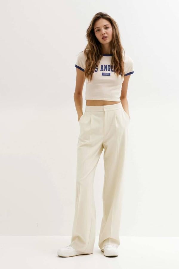 Pantalón de vestir estilo loose fit con tiro medio, bolsillos, detalles de pinzas y perneras anchas, de Pull&Bear. Hazte con él en seis colores, a 25,99 euros.