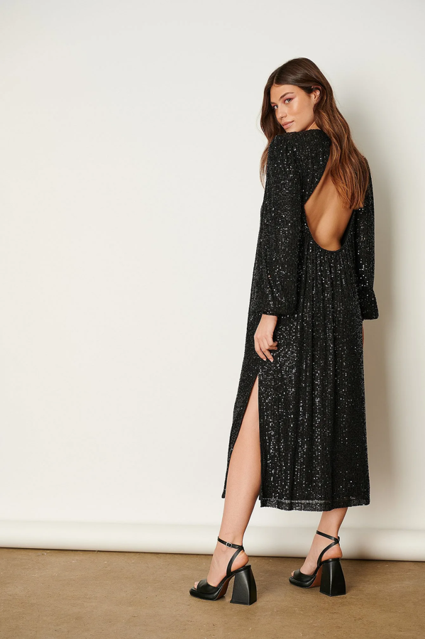 Vestido midi de lentejuelas negras con brilli brilli. Además, su diseño está confeccionado con la espalda descubierta. Es de NA-KD. Precio: 34,78 €.