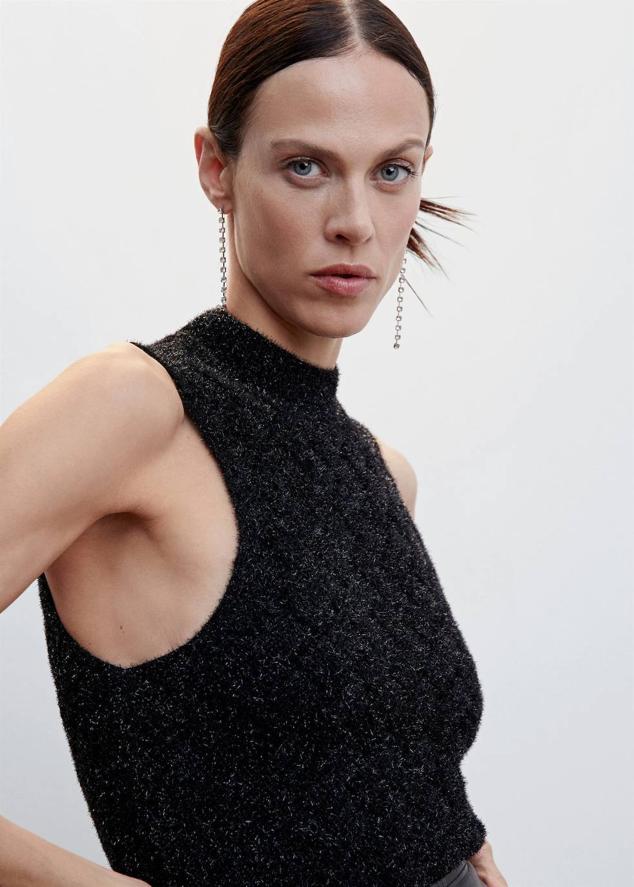 Top en tejido de punto con lúrex efecto pelo, cuello perkins y manga sisa, en negro y plata, de Mango. Puedes encontrarlo por 29,99 euros.