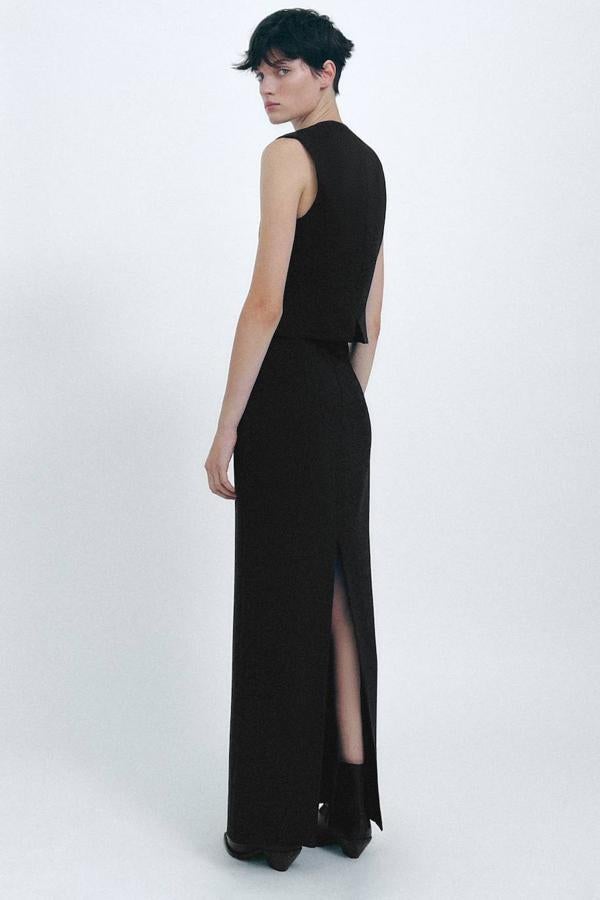Falda larga con silueta de tubo en tejido de lana, tiro alto, abertura posterior y detalles de bolsillos con solapa delanteros, color negro, de Zara. Cuesta 49,95 euros.