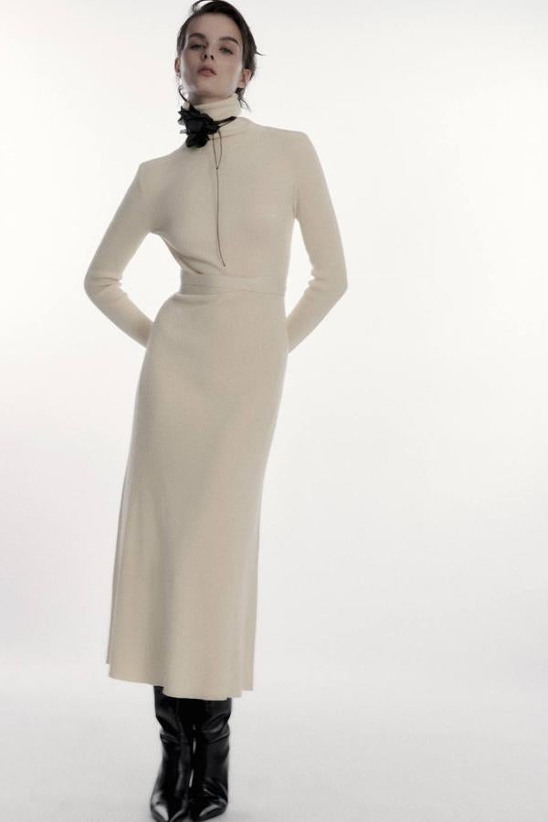 Vestido largo en tejido de punto con cuello alto, manga larga, corte entallado, bajo en evasé y detalle de cinturón, de Zara. Puedes encontrarlo por 35,95 euros.