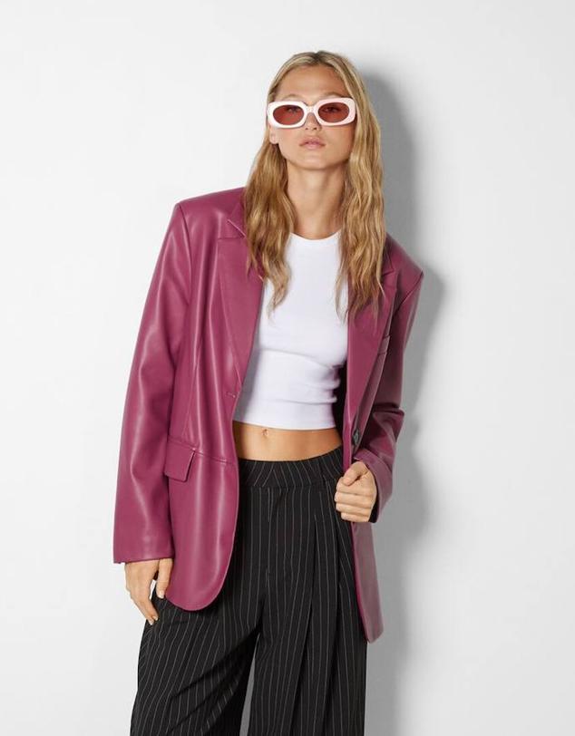 Americana oversize en tejido efecto piel con manga larga, hombros marcados, cuello solapa y bolsillos, color rosa, de Bershka. Tiene un coste de 25,19 euros.