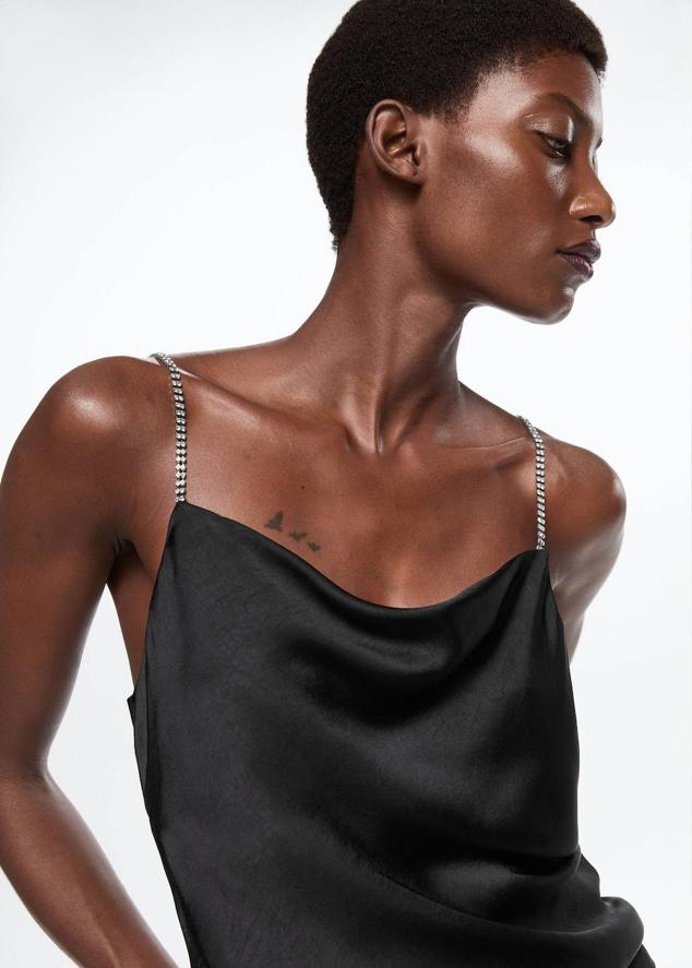 Top lencero en tejido satinado con escote fluido, tirantes de strass y espalda baja, en negro, de Mango. Lo comprarás por 25,99 euros.