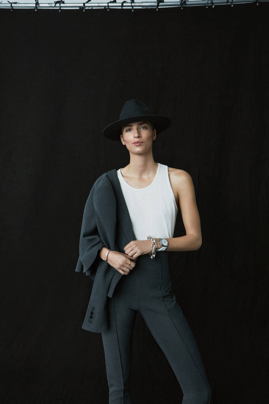 Traje de chaqueta y pantalón, de Pertegaz; camiseta de Abanderado y sombrero de El Corte Inglés. La pulsera de eslabones es de Hermès; el reloj, de Panerai; y la pulsera y el anillo de la mano derecha, de Tous.