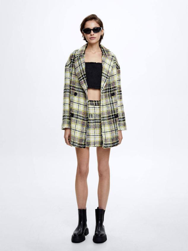 Traje de chaqueta y falda corta en tejido de tweed con estampado a cuadros multicolor. Hazte con él por 69,99 euros y 32,99 euros, respectivamente.